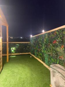un balcone con un giardino verde di notte di كوخ خزامى الباحة ad Al-Bāha