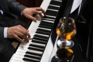 a man in a suit playing a piano at Villa Nicolli Romantic Spa Resort - Adults Only in Riva del Garda