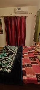 a bedroom with a bed with a quilt on it at Happy Shiva Cafe & Homestay in Rishīkesh