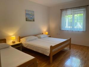 a bedroom with two beds and a window at Dragica in Valbandon