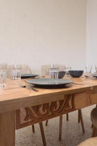 a wooden table with glasses and a plate on it at Joséanna in Ehden