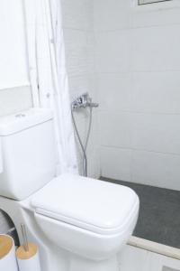 a white bathroom with a toilet and a shower at Joséanna in Ehden
