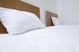 two beds with white pillows in a bedroom at Joséanna in Ehden