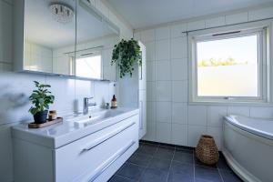a bathroom with a sink and a tub and a window at Reinefjorden Family House in Reine