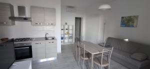 a kitchen with a table and a couch in a room at Le Pigne casa vacanze. in Pollica