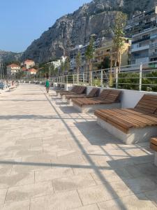 una fila di panchine con una montagna sullo sfondo di Sea view Panorama Apartment L a Omiš (Almissa)
