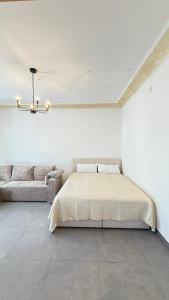 a white bedroom with a bed and a couch at Home Apartments Five in Wuppertal