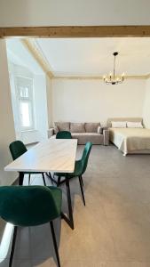 a living room with a table and green chairs at Home Apartments Five in Wuppertal +9 photos