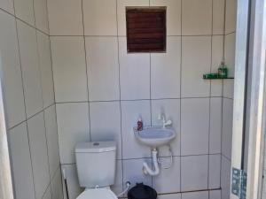 a bathroom with a toilet and a sink at Chácara Mergulho Azul in Belém