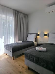 a bedroom with two beds and a window at W64 Apartamenty in Płock