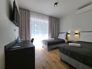 a hotel room with two beds and a television at W64 Apartamenty in Płock