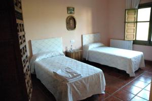 a hotel room with two beds and a table at La Quinta de Melque in San Martín de Montalbán