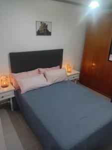 a bedroom with a large bed with two night stands at Apat sombrero A Cunit Beach in Cunit