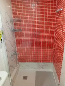 a bathroom with a shower with red tile at Apat sombrero A Cunit Beach in Cunit +11 photos