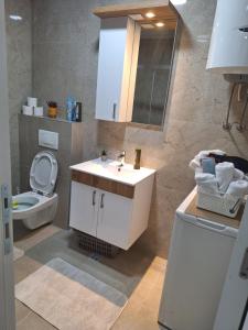a bathroom with a white sink and a toilet at Apartman L&S in Doboj +13 photos