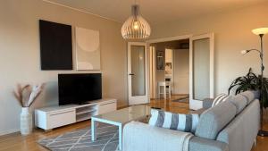 a living room with a couch and a tv at Apartment Pilvenveikko in Kokkola