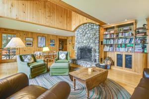 Il comprend un salon doté de meubles et d'une cheminée en pierre. dans l'établissement Lakefront Escape with Deck and Kayaks in Lovell!, à North Lovell
