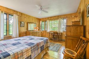 - une chambre avec un lit, des murs en bois et des fenêtres dans l'établissement Lakefront Escape with Deck and Kayaks in Lovell!, à North Lovell
