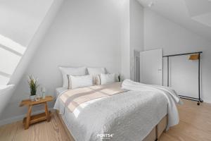 une chambre blanche avec un grand lit et une table dans l'établissement Ferienhaus ReetCottage 24 Dörphof, à Dörphof