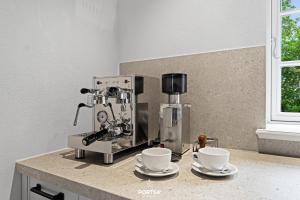 - une machine à café assise sur un comptoir avec deux tasses dans l'établissement Ferienhaus ReetCottage 24 Dörphof, à Dörphof 34 autres photos