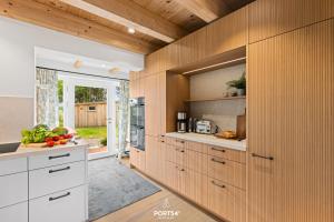 une cuisine avec des placards en bois et une grande fenêtre dans l'établissement Ferienhaus ReetCottage 24 Dörphof, à Dörphof