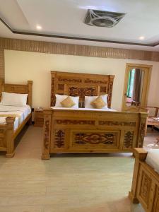 1 Schlafzimmer mit 2 Betten und einem großen Bettrahmen aus Holz in der Unterkunft Arcadian Resort Skardu in Skardu