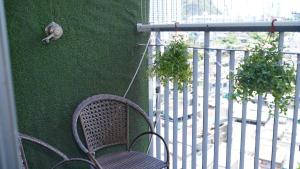 a chair sitting on a balcony with a green wall at Là Nhà - Homestay Hạ Long in Ha Long