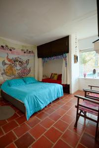 una camera da letto con un letto con un piumone blu di Cabañita en medio de la Naturaleza Mesa de Ruitoque a Piedecuesta