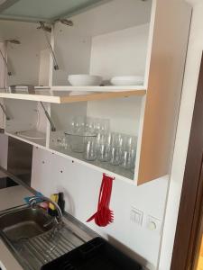 a kitchen with a sink and some glasses on shelves at Pirin 7 in Pazardzhik