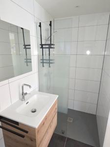 a white bathroom with a sink and a shower at Nieuwe vakantie woning Serooskerke in Serooskerke