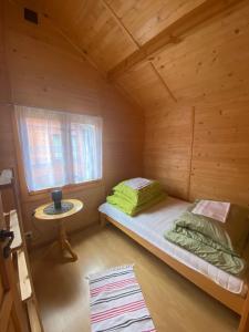 a small room with a bed in a wooden cabin at Plażowa Domki in Mielenko