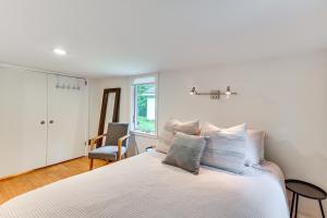 a bedroom with a white bed with a chair at Walk to Kelsey Lake Cassopolis Home with Yard! in Cassopolis