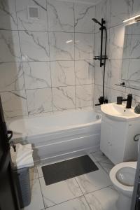 a white bathroom with a tub and a sink at Luxury Home in Cîmpulung +15 photos