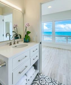 a bathroom with a white sink and a large mirror at Haena Beach House TVNC#1258 in Hanalei