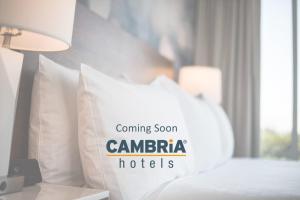a bed with a pillow with the words coming soon canaru hotels at Cambria Hotel Northlake Conference Center - Roanoke in Northlake