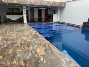 une piscine avec de l'eau bleue dans un immeuble dans l'établissement Hotel maripipark, 