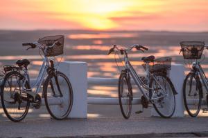 three bikes parked next to the ocean at sunset at Domaine de Diane in Quend-Plage