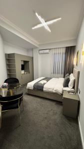a bedroom with a large bed and a table at Sim Plaza Hotel in Ejmiatsin +67 photos