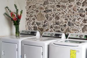 two washing machines and a vase of flowers in a room at CASA SAUTO 2 BR 2BA balcony Historic Building in Mexico City