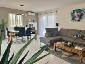 ein Wohnzimmer mit Sofa und Tisch in der Unterkunft Villa avec piscine in Landorthe