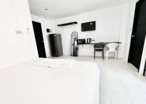 Un dormitorio con una cama blanca y un escritorio. en Patong Canal Villa R208, en Patong Beach