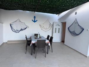 - une salle à manger avec une table, des chaises et un mur dans l'établissement Gio Bella, à Sutomore