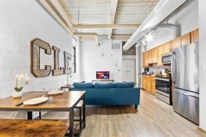 Una sala de estar con un sofá azul y una mesa. en Loft on Superior l DT Cleveland l Parking l Café, en Cleveland 7 fotos más