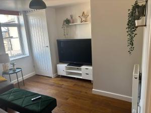 a living room with a flat screen tv on a white cabinet at Fresh comfy space, feel at home. in Gravesend