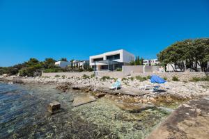 a house on the shore of a body of water at Villa Mir Punta Radman in Petrcane