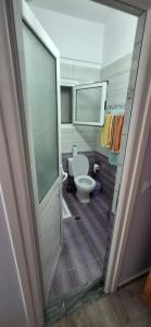 a bathroom with a toilet and a door open at Villa Margot in Ksamil