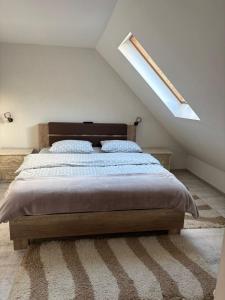 une chambre avec un grand lit avec une lucarne dans l'établissement Cabana Ana, à Feleacu