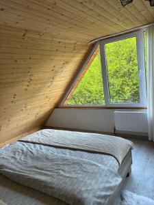 un letto in una camera con una grande finestra di Cabana Ana a Feleacu
