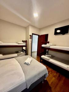 a room with three beds and a television in it at Pousada Recanto das Cores in Penha