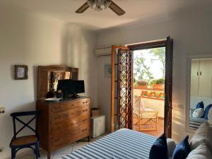 a bedroom with a bed and a dresser and a window at La Casa di SASI in Sabaudia